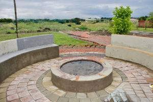 a brick patio with a fire pit in the middle at Saints boutique lodge in Bloemfontein