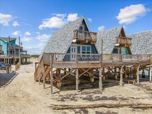 a home on the beach with a large deck at Sleep Over the Ocean in Surfside Beach
