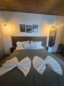 a bedroom with a bed with two bows on it at Mirante Vista Nobre in Maricá +37 photos