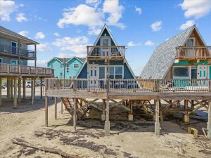 a row of houses on a pier on the beach at Sleep Over the Ocean in Surfside Beach +19 photos