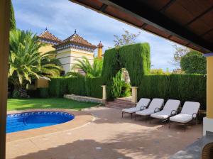 a group of chairs sitting next to a swimming pool at Andalusian experience in Ronda