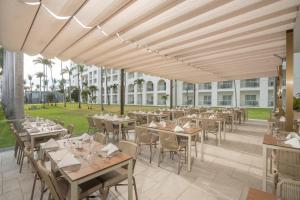 a restaurant with tables and chairs on a patio at Riu Flamingos - All Inclusive in Nuevo Vallarta