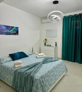 a bedroom with a large bed with a blue comforter at Armonia dell'Etna in Santa Venerina