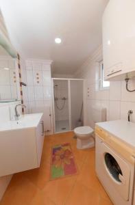 a bathroom with a toilet and a sink and a washing machine at Apartment Dea 3 Spacious Lower-Level Apartment in Crikvenica +16 photos