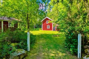 a red barn with a tree in the yard at "Björkhorva" in Vimmerby +25 photos