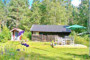 a small cabin with a table and chairs in a yard at "Björkhorva" in Vimmerby