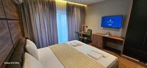 a hotel room with a bed and a flat screen tv at Hotel Diamant in Tropojë