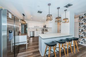 a kitchen with white cabinets and bar stools at Hidden Gem 3 Bedroom Home in Largo