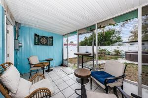 a screened in porch with chairs and a table at Hidden Gem 3 Bedroom Home in Largo