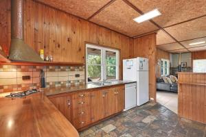 a kitchen with wooden cabinets and a white refrigerator at Aloha Amity in Amity Point