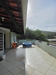 eine Außenterrasse mit blauem Pool an einem Haus in der Unterkunft kibeleza in Ilhéus