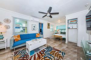 a living room with a blue couch and a ceiling fan at Sunshine Tropical Villa in Largo