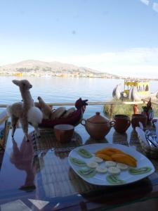 a table with a plate of food on it next to the water at TiticacaIntiLodge in Puno