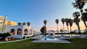 a resort with a swimming pool and palm trees at Andromeda Hotel Apartments in Kos