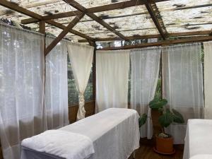 a bedroom with a bed with white curtains and a ceiling at Cabañas La Cima in San Francisco