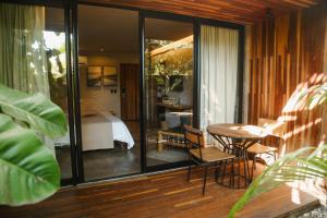 a room with a bed and a table and chairs at Makena Hotel in Icaraí