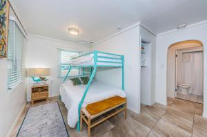 a bedroom with a bunk bed and a bathroom at Teal Tropical Villa in Largo