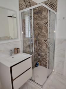a shower with a glass door next to a sink at Holiday Home Varese- Family & Group stay with private parking in Varese +34 photos