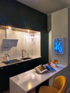 a kitchen with a sink and a counter with a book on it at Il Sonetto Boutique Apartment - private garage in Mantova