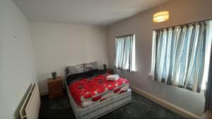 a bedroom with a bed with a red blanket at The London Residence in Enfield