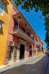 a colorful building with a balcony on a street at El Marques Hotel Boutique By GEH Suites in Cartagena de Indias