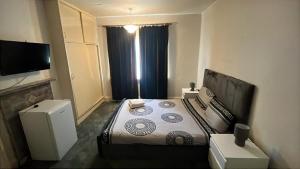 a hotel room with a bed and a television at The London Residence in Enfield