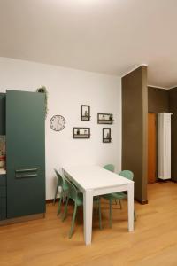 a dining room with a white table and green chairs at Solferino Green - Modern Stay - Near station in Brescia