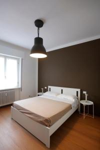 a bedroom with a large white bed and a lamp at Solferino Green - Modern Stay - Near station in Brescia