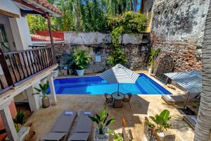 a patio with a swimming pool and a house at El Marques Hotel Boutique By GEH Suites in Cartagena de Indias