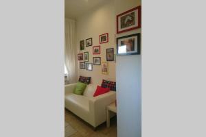 a living room with a couch and pictures on the wall at La Medialuna in Montespertoli