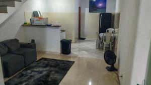 a living room with a couch and a kitchen at Hostel Sundays in Angra dos Reis