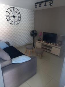 a bedroom with a bed and a clock on the wall at Maison agréable à Oléron in Dolus-d'Oléron