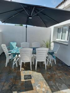 a table and chairs under an umbrella on a patio at Maison agréable à Oléron in Dolus-d'Oléron