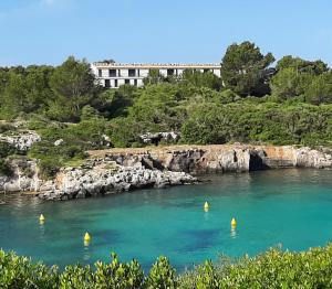 a body of water with yellow buoys in the water at Apartamento Can Rupit Playa Santandria con jardin y piscina in Son Carrio