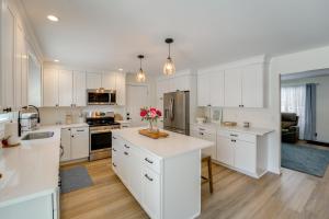 a large kitchen with white cabinets and a kitchen island at Deck, Fire Pit! Fully Updated Home Near Lake Huron in Caseville +16 photos