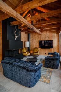 a living room with two couches and a fireplace at Villa Klainguti in Pontresina