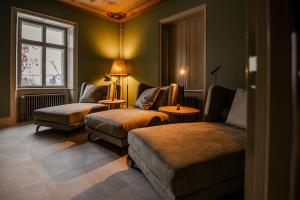 a living room with a couch and chairs and a window at Villa Klainguti in Pontresina