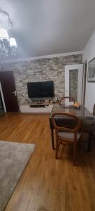 a living room with a table and a tv at Charmante chambre chez l'habitant in Ivry-sur-Seine
