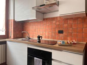 a kitchen with a sink and a stove top oven at La porta sul Viale in Cuneo