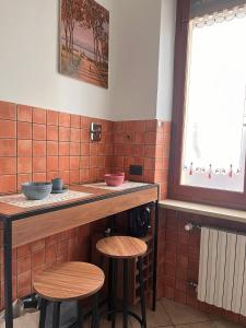 a kitchen with two stools and a counter with bowls at La porta sul Viale in Cuneo +12 photos