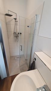 a shower with a glass door next to a toilet at Monteurzimmer 05 in Parchim in Parchim +15 photos