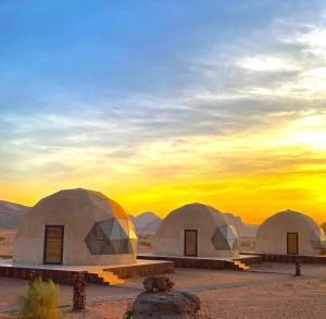 a group of three domes in the desert at sunset at Rum Horizon Camp& Tours in Wadi Rum