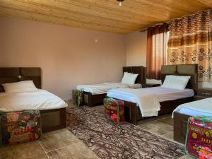 a room with three beds and a window at Naif Bedouin tour in Wadi Rum