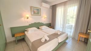a bedroom with a bed with two towels on it at Andromeda Hotel Apartments in Kos +128 photos