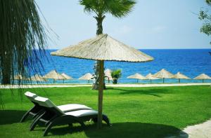 een stoel en een parasol naast een strand bij Flora Garden BEACH - Couples Concept - Adults over 16 Only in Kızılot