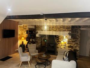 a living room with a fireplace and a stone wall at Gite la pause corrézienne in Troche