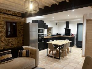 a kitchen and living room with a table and a couch at Gite la pause corrézienne in Troche