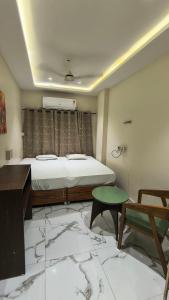 a bedroom with a bed and a desk and a table at Hotel flexistays central dhantoli in Dhantoli +6 photos