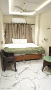 a bedroom with a bed with a window and a chair at Hotel flexistays central dhantoli in Dhantoli