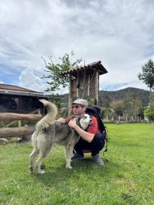 a man holding a dog in a field at El Corral in Cuenca
